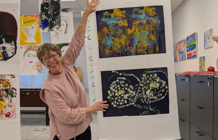 Frau zeigt lachend auf ein Bild