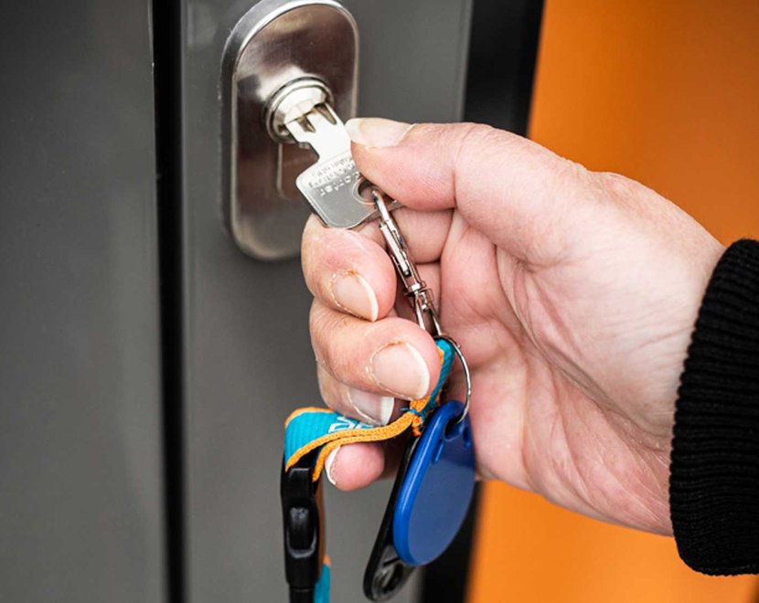 Hand mit Schlüssel, die Tür aufschließt